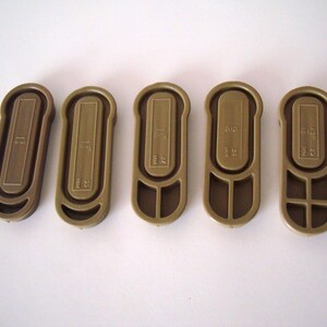 May include: Five brown plastic key tags with different numbers and letters printed on them. The numbers are 51, 52, 53, 54, and 55.