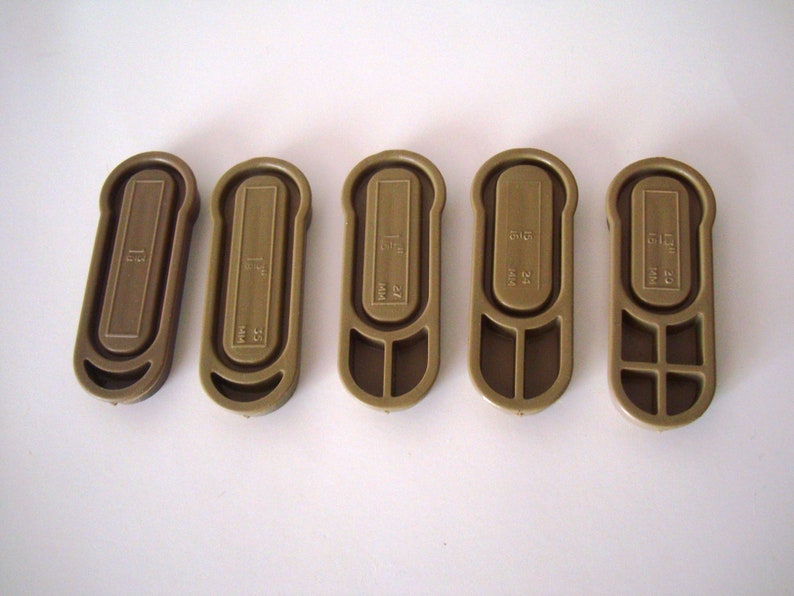 May include: Five brown plastic key tags with different numbers and letters printed on them. The numbers are 51, 52, 53, 54, and 55.