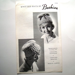 May include: Black and white image of a knitting pattern booklet for hats. The booklet is titled "Knitted Hats by Beehive" and features two women wearing different styles of knitted hats. The text on the booklet says "Designed especially for knitting with Canadiana Knitting Worsted or Canadiana Shetland Style or Beehive Caressa."