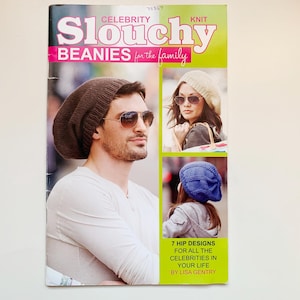 Peut inclure: Couverture de magazine avec le titre "Celebrity Slouchy Beanies for the family". La couverture présente des images de personnes portant des bonnets. L'image principale montre un homme portant un bonnet marron et des lunettes de soleil.