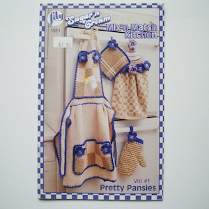 Peut inclure: Livret de modèles de crochet pour un ensemble de cuisine avec un tablier, un dessous de plat et un torchon. Le modèle s'appelle "Pretty Pansies" et fait partie de la série "Mix-n-Match Kitchen" de Lily Sugar'n Cream. Le modèle est le volume n° 1 et coûte 3,95 $.