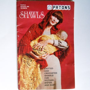 May include: A vintage book cover for knitting and crocheting shawls. The cover features a woman wearing a red shawl and holding a baby wrapped in a yellow shawl. The book is titled "Shawls" and is published by Patons.