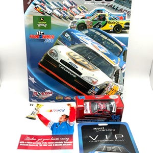 Puede incluir: Una colección de recuerdos de NASCAR, que incluye un programa de recuerdos, coches de fundición y tarjetas VIP. El programa presenta coches de carreras y el texto "500 Talladega Superspeedway". Otros artículos incluyen un coche de fundición en una caja y una tarjeta VIP.