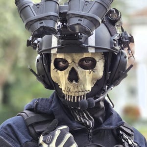 May include: A tactical helmet with mounted night vision goggles, a skull-patterned face mask, and black communication headset. The gear includes a dark blue uniform, a black tactical vest, and black gloves featuring a white skeletal hand print.