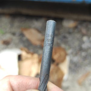Op de afbeelding: Een donkergrijze metalen boor met een cilindrische schacht en een spiraalvormige snijkant. Het oppervlak van het metaal is gegraveerd met de tekst 6.9, P6M5 en 35. Het gereedschap heeft een gladde, afgeronde punt en een egale, matte afwerking.