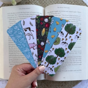 May include: Set of six colorful bookmarks featuring different farm animal and vegetable illustrations. The bookmarks are printed on white cardstock and have a matte finish.