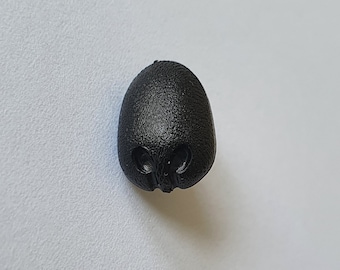 May include: A black plastic button with a skull design.