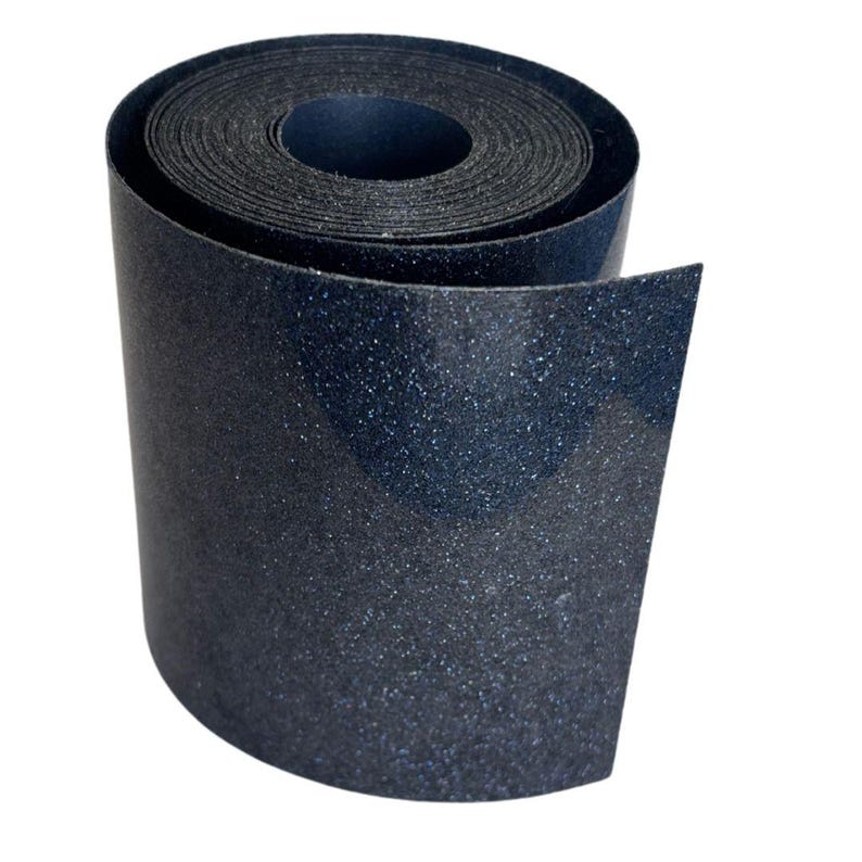 May include: A roll of dark blue, textured material with a glittery appearance. The material is tightly wound, revealing the inner layers. The edges of the roll are visible, and the background is plain white.