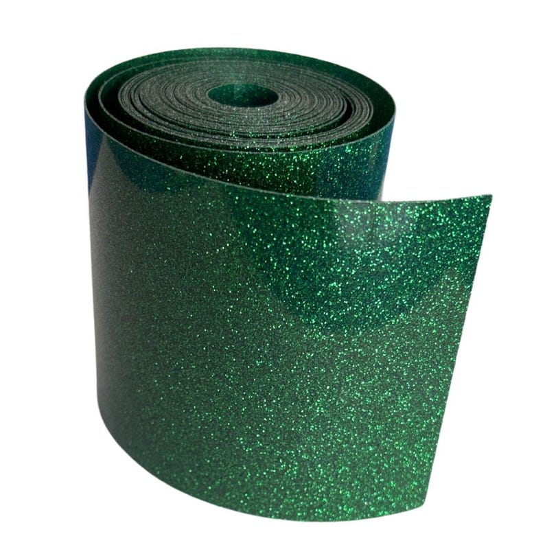 May include: A roll of emerald green glitter ribbon. The ribbon is tightly wound, with the end unfurled, revealing the shiny, textured surface. The glitter catches the light, creating a sparkling effect. Ideal for crafts and decorations.