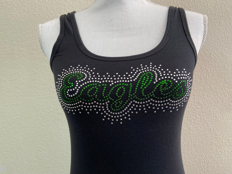 May include: Black tank top with a green and silver rhinestone design that says "Eagles".