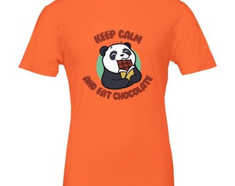 Puede incluir: Camiseta naranja con un panda de dibujos animados comiendo chocolate. El panda es blanco y negro, sobre un círculo verde. El texto "KEEP CALM AND EAT CHOCOLATE" es marrón, arqueado alrededor del panda.