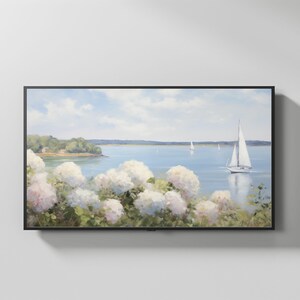 May include: A framed landscape painting depicts a serene coastal scene. White sailboats glide on a blue sea under a cloudy sky. Lush white and pink hydrangeas bloom in the foreground, with a green shoreline in the distance.