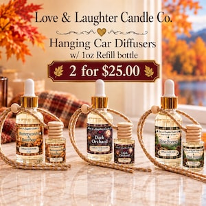 May include: Three sets of Love & Laughter Candle Co. hanging car diffusers with 1oz refill bottles. Each set includes a glass bottle with a gold cap and hanging cord, and a smaller diffuser bottle. Labels read Butterscotch & Bourbon, Dark Orchard, and Pine Forest.