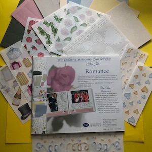 May include: A Creative Memories Collection Scrap Pack titled "Romance" with a pink rose on the cover. The pack includes a variety of stickers, papers, and embellishments for scrapbooking. The back of the pack shows a photo of a wedding couple and lists the contents of the pack.