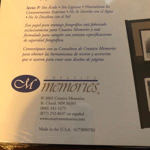 May include: A close-up of a product packaging for Creative Memories photo albums. The packaging is white with blue and black text. The text reads "Creative Memories" and includes the company's website and phone number. The packaging also includes the text "Made in the U.S.A. 6173090702".