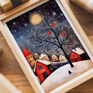 May include: A framed art print depicts a winter night scene with a full moon, a tree with red fruit, and snow-covered houses. The artwork is in a light wood frame, surrounded by wrapped gifts and holiday greenery.