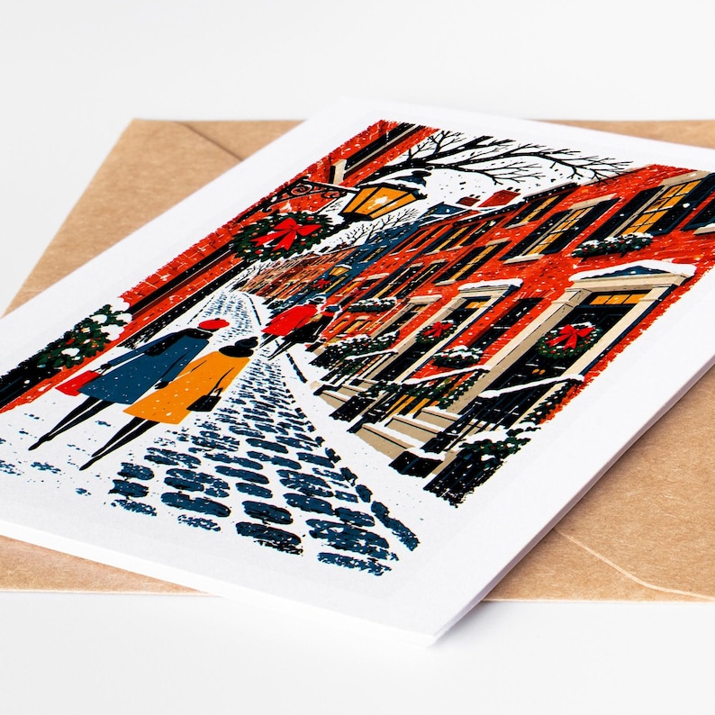 Boston Christmas card lying on a kraft envelope, folk art Beacon Hill gas lamps and brick row houses under snow