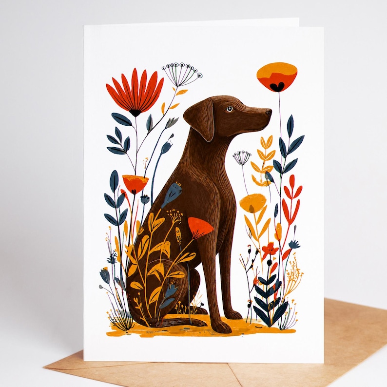 May include: A greeting card featuring a brown dog sitting in profile, surrounded by stylized botanical illustrations of red, orange, and blue flowers and foliage on a white background. The dog is positioned centrally among the colorful plants.