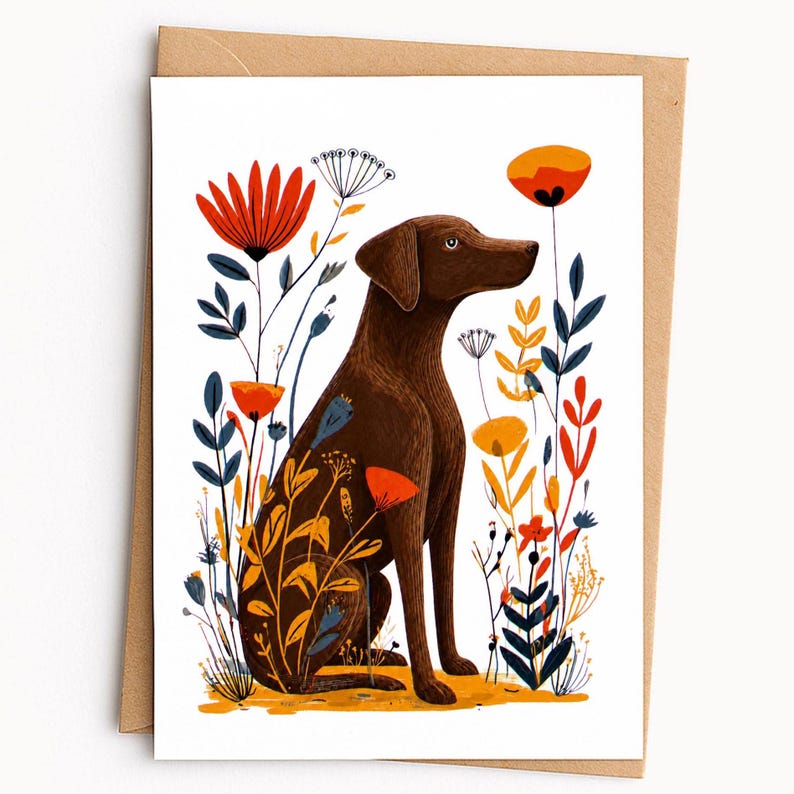 May include: A greeting card featuring a brown dog sitting in a field of stylized flowers. The illustration includes tall red, orange, and blue floral stems surrounding the dog, set against a plain white background with a brown envelope behind it.