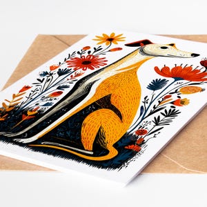 May include: A white greeting card featuring a stylized illustration of a yellow and white dog sitting among vibrant orange, red, and dark blue flowers. The dog has a long neck and is surrounded by botanical elements on a plain white background.