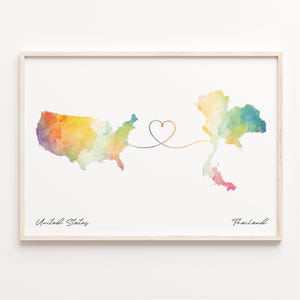 May include: A watercolor print of the United States and Thailand connected by a heart-shaped line. The text "United States" and "Thailand" are written below the maps.