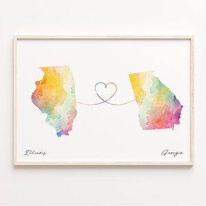 May include: A watercolour print of the states of Illinois and Georgia connected by a heart-shaped line. The states are painted in shades of yellow, orange, pink, and green. The text "Illinois" and "Georgia" are written below the states.