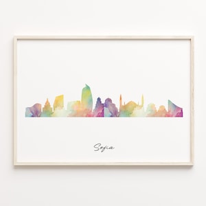 May include: A framed watercolor print featuring the Sofia skyline in a vibrant array of colors. The artwork showcases the city's silhouette against a white background, with the name "Sofia" written in cursive below the skyline.