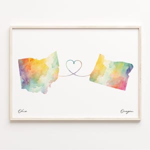 Może przedstawiać: Aquarela przedstawiająca stany Ohio i Oregon połączone linią w kształcie serca. Stany są pomalowane w tęczowych kolorach. Pod stanami widnieją napisy "Ohio" i "Oregon".