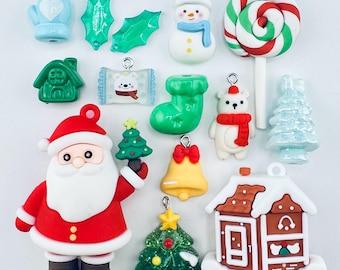 Pode incluir: Uma coleção de amuletos e enfeites com tema natalino. Inclui uma figura do Papai Noel, um boneco de neve, uma casa de gengibre, um pirulito, um sino, uma luva, folhas de azevinho e ursos polares.