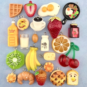 May include: A selection of miniature food charms, featuring a waffle, strawberry, fried egg, coffee cup, orange juice bottle, glass of milk, kiwi slice, banana bunch, and a slice of cheese. Each charm has a silver loop for crafting.