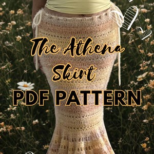 Op de afbeelding: Een gehaakte rok met de tekst "The Athena Skirt PDF PATTERN". De rok is een mix van gele, perzik- en crèmekleuren. Het heeft een uitlopende zoom en een tailleband met trekkoord. De achtergrond is een veld met wilde bloemen.