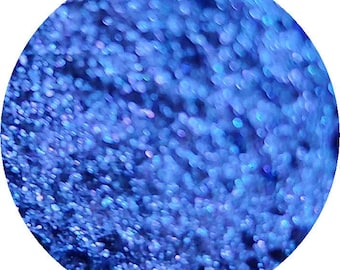 May include: A close-up image of a circular design filled with sparkling blue glitter. The glitter particles vary in size, creating a textured, shimmering effect. The overall appearance is a vibrant, eye-catching display of color and light.