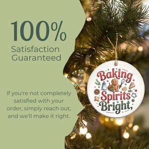 May include: A round white Christmas ornament with the words "Baking Spirits Bright" in red and green. The ornament features a gingerbread man, baking tools, and festive illustrations. The background includes a Christmas tree and the text "100% Satisfaction Guaranteed."