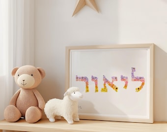 May include: A framed print featuring the Hebrew name "ליאור" spelled out using colourful flower petals. The print is displayed on a wooden shelf with a teddy bear and a white stuffed lamb.
