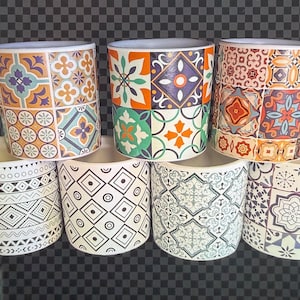 May include: A collection of seven ceramic plant pots. The pots feature various geometric and floral patterns in colors like orange, blue, green, and white. The pots are cylindrical and have a smooth finish.