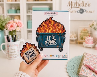 May include: A blue dumpster sticker with orange and yellow flames and the text IT'S FINE, accompanied by a smaller sticker featuring a burning square with the text STILL FINE. Both stickers feature a cartoon fire design on a white backing card.