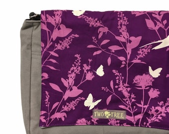 Bolso bandolera gris con estampado de golondrinas y mariposas moradas para tablet, portátil y pañales.