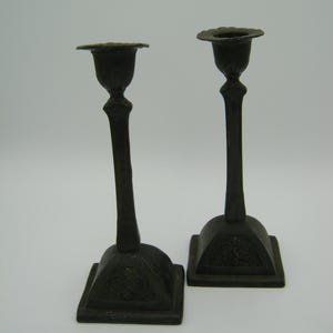 A pair of antique art nouveau pewter candelsticks with floral decoration candle holder