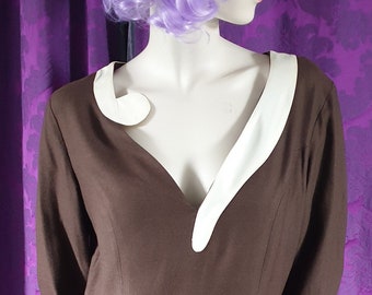 Könnte beinhalten: Ein braunes Kleid mit einem weißen Kragen und einem V-Ausschnitt. Das Kleid ist figurbetont und hat lange Ärmel. Das Model trägt eine lila Perücke.