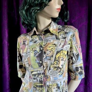 Może przedstawiać: Koszula zapinana na guziki z krótkim rękawem z nadrukiem komiksowym. Koszula posiada kolaż paneli komiksowych w różnych kolorach, w tym żółtym, niebieskim i różowym. Koszula ma kołnierzyk i czarne guziki.