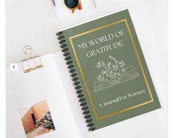 May include: A green spiral bound journal with a gold border and the text "My World of Gratitude A Journal For Women".