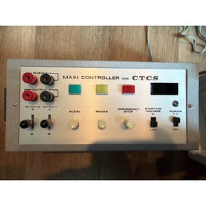 May include: A silver-colored main controller for C.T.C.S. with various buttons, switches, and output ports. The controller features red and black output ports, green, yellow, and red buttons, and a digital display. The text "MAIN CONTROLLER FOR C.T.C.S." is visible.