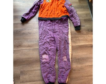 Traje de carreras Pyrotect vintage morado y naranja con certificación SFI, Nomex y parches de Kevlar.