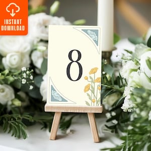 May include: A cream-coloured table number eight card with floral corner designs and yellow flowers. The card is displayed on a small wooden easel. The top left corner has an orange square with the words "INSTANT DOWNLOAD" and an icon.