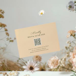 May include: A light beige wedding invitation card with elegant script and a QR code. The text reads "Kindly RSVP by 1st Feb 2028" and includes a website address. The card is surrounded by soft, neutral-toned flowers.
