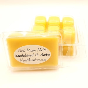 Puede incluir: Un recipiente de plástico transparente que contiene varias ceras perfumadas amarillas. La etiqueta dice "New Moon Melts Sandalwood & Amber NewMoonEve.com". Las ceras tienen forma rectangular y la combinación de colores es amarilla y transparente.
