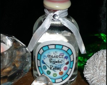 May include: A clear glass bottle with a white ribbon tied around the neck. The bottle contains a clear liquid and has a label that reads "quartz crystal potion". The label is decorated with a circle of colorful gemstones.