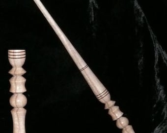 以下が含まれることがあります： 薄い茶色の仕上げと黒いアクセントが付いた木製の杖。杖は丸みを帯びた先端を持つ装飾的なセグメントデザインです。