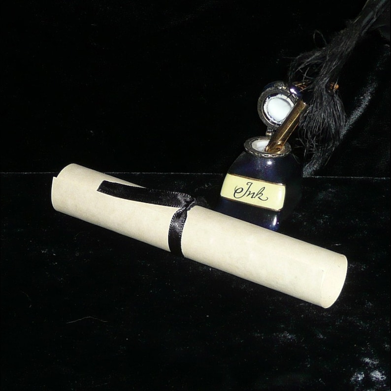 May include: A rolled up piece of parchment paper tied with a black ribbon, next to a blue inkwell with a quill pen and the word "Ink" written on it.