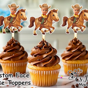 Può includere: Tre cupcake al cioccolato marrone con glassa marrone e codette. Ogni cupcake ha un topper per torta personalizzato con un'immagine di un bambino in un cappello da cowboy che cavalca un cavallo marrone. Il testo "Custom Face Cake Toppers" è in basso nell'immagine.